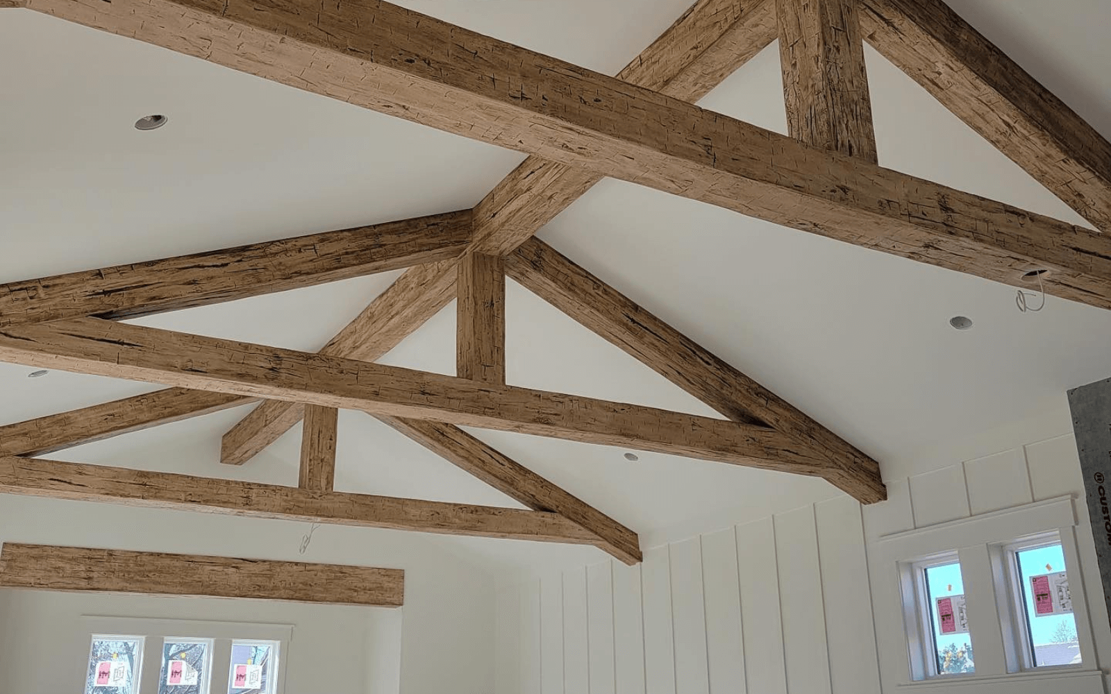 Light rustic faux trusses in a bright vaulted room