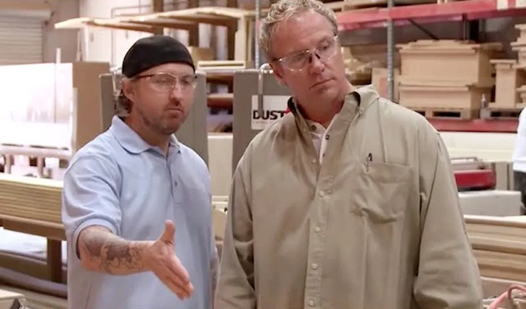 Still from the American Ruckus feature: two men on a shop floor stacked with fabricated beam components